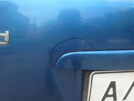 Очаг ржавчины на крышке багажника KIA Ceed рядом с накладкой освещения